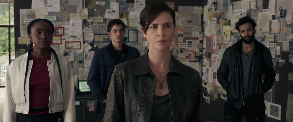 Charlize Theron, KiKi Layne e la loro squadra stanno con le spalle al tabellone della cospirazione in The Old Guard.