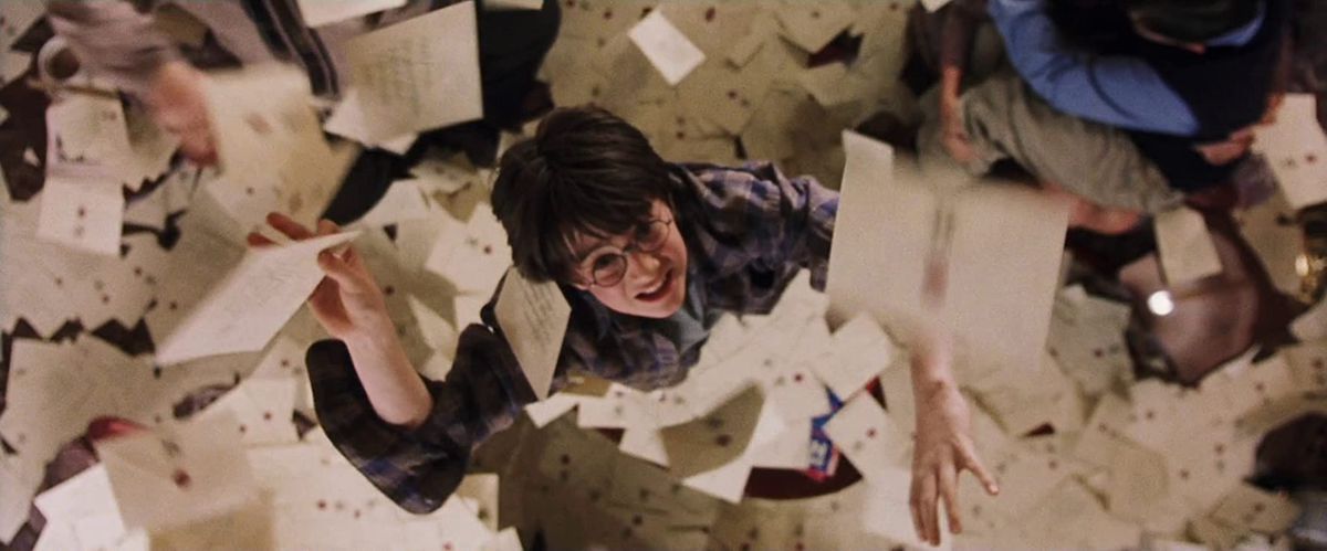 Harry (Daniel Radcliffe) afferra le lettere che cadono dal soffitto