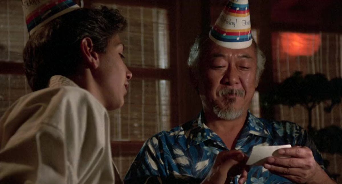 Il signor Miyagi (Pat Morita) legge una nota di Daniel (Ralph Macchio)
