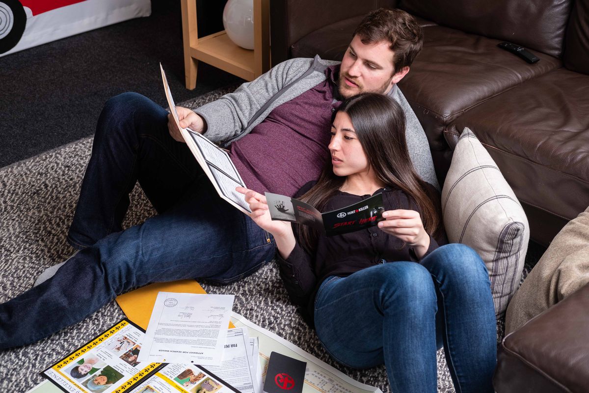 Una coppia si siede insieme, guardando le informazioni per risolvere un mistero