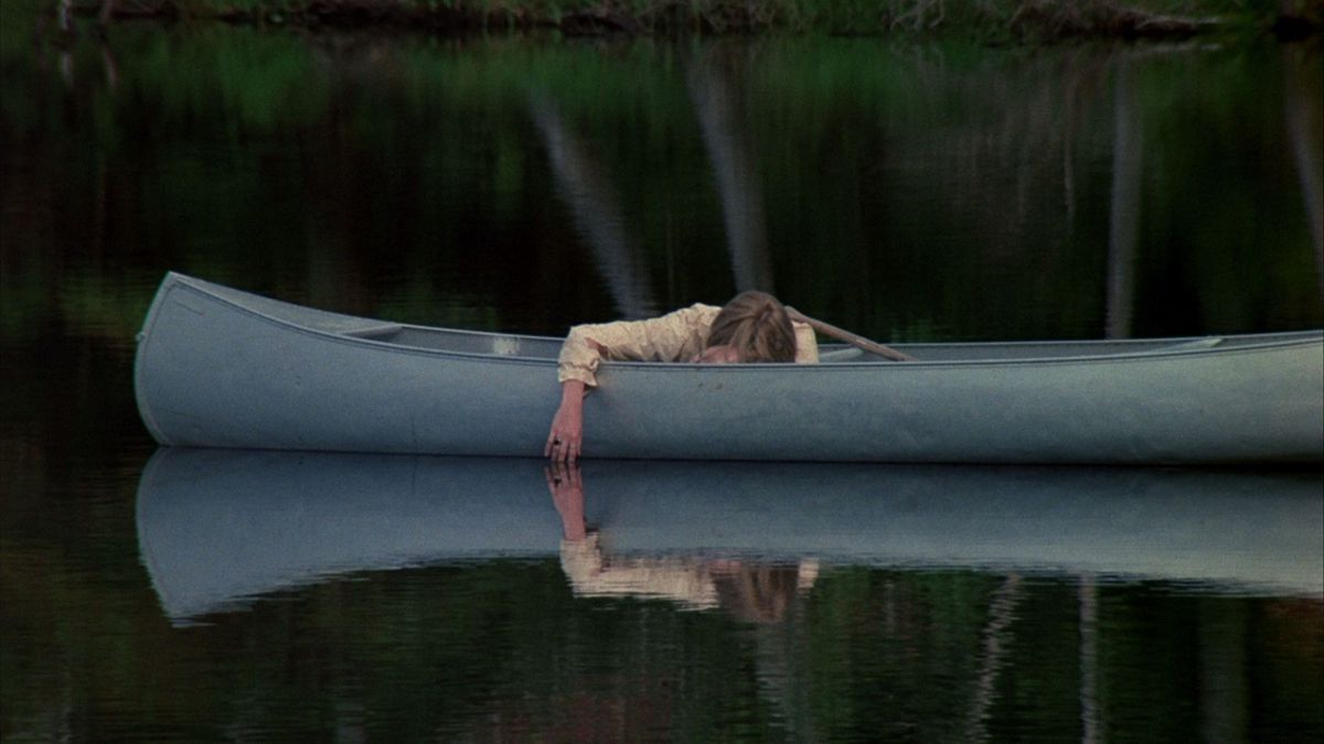 Adrienne King venerdì 13 giace svenuta in una canoa su un lago che riflette il suo braccio penzolante.