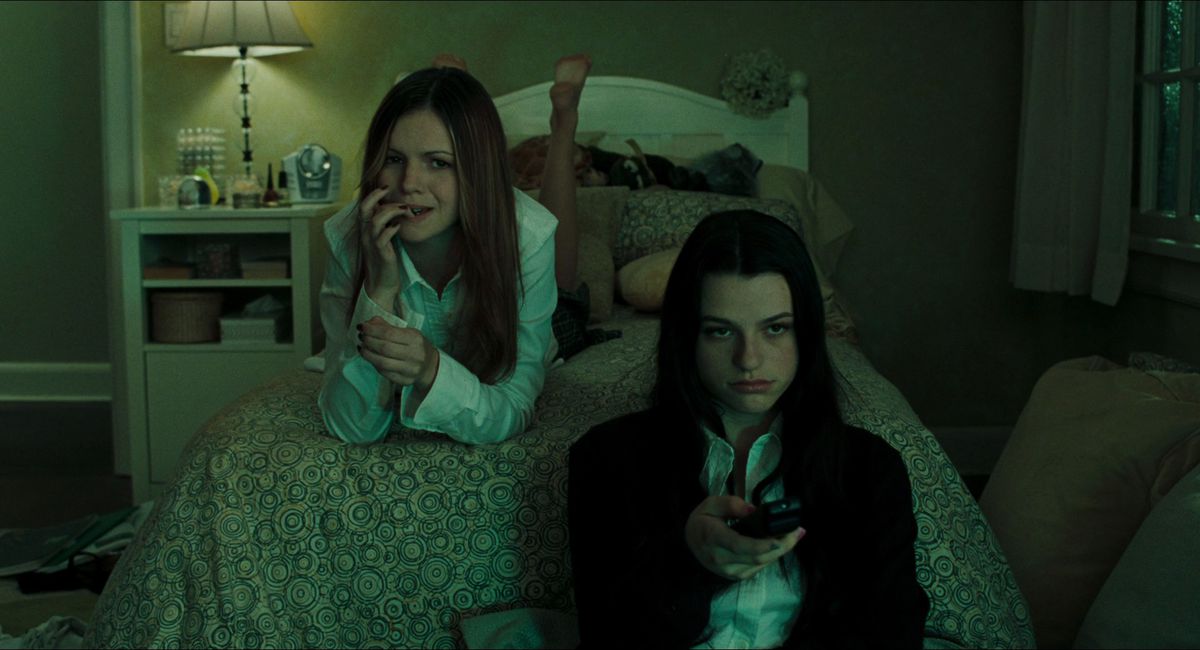 Le adolescenti Katie (Amber Tamblyn) e Becca (Rachael Bella) guardano la televisione sul letto di Katie in uno screenshot da The Ring