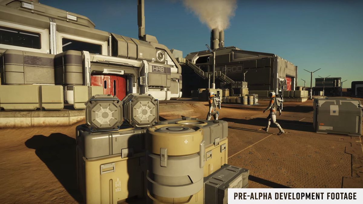 Due giocatori camminano tra casse e scatole su un pianeta polveroso. Il cielo è di un azzurro pallido e indossano tute spaziali.