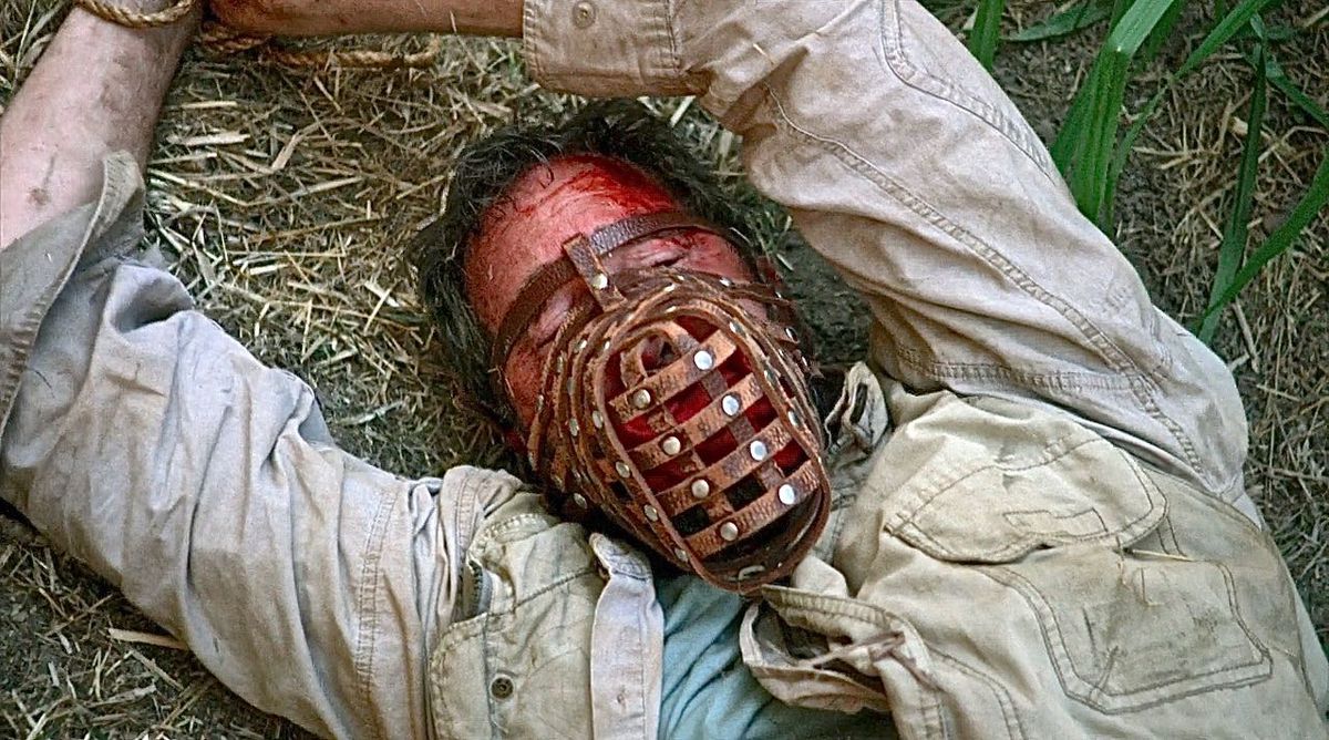 a bloodied dude in a dog muzzle