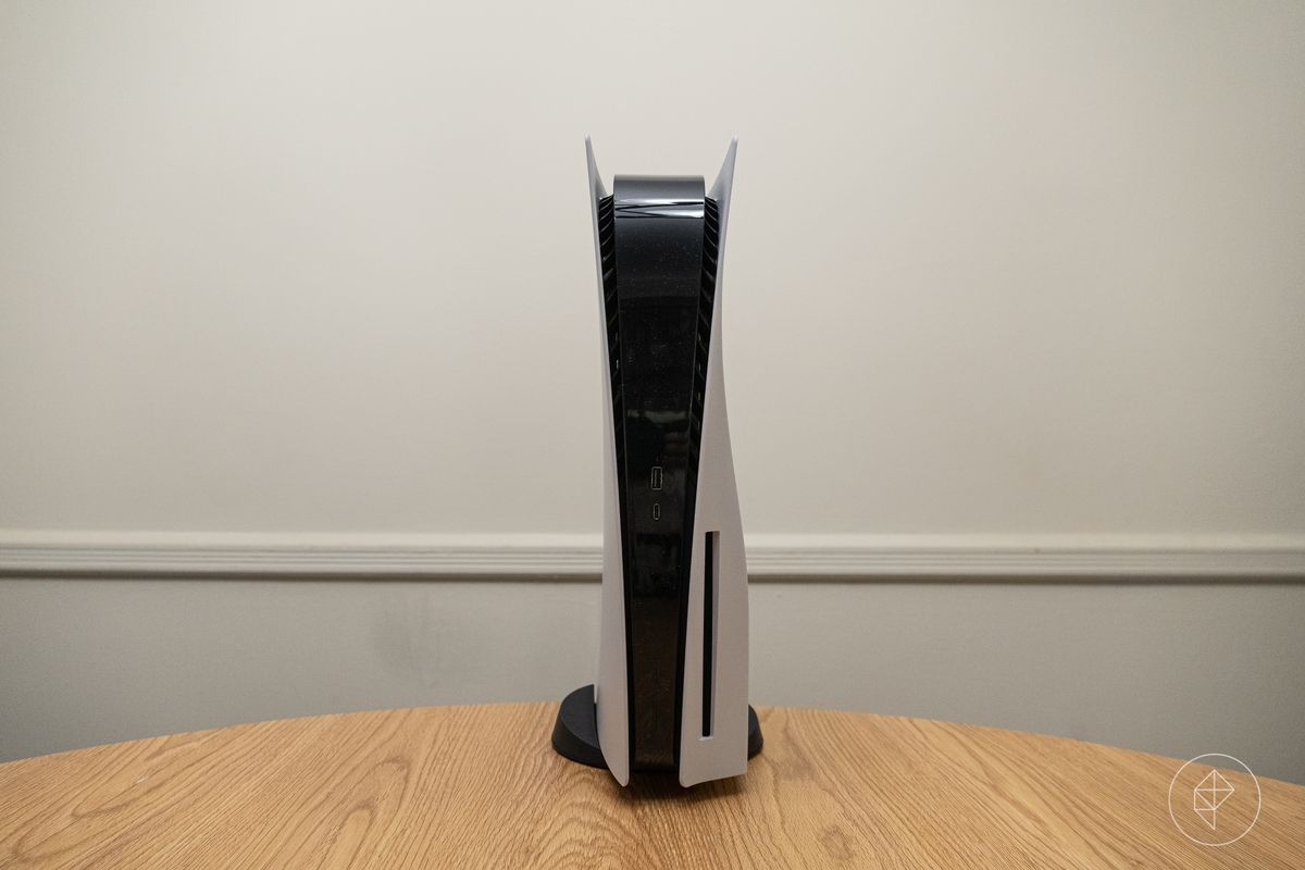 un'ampia foto della PlayStation 5 in piedi verticalmente su un tavolo di legno rotondo