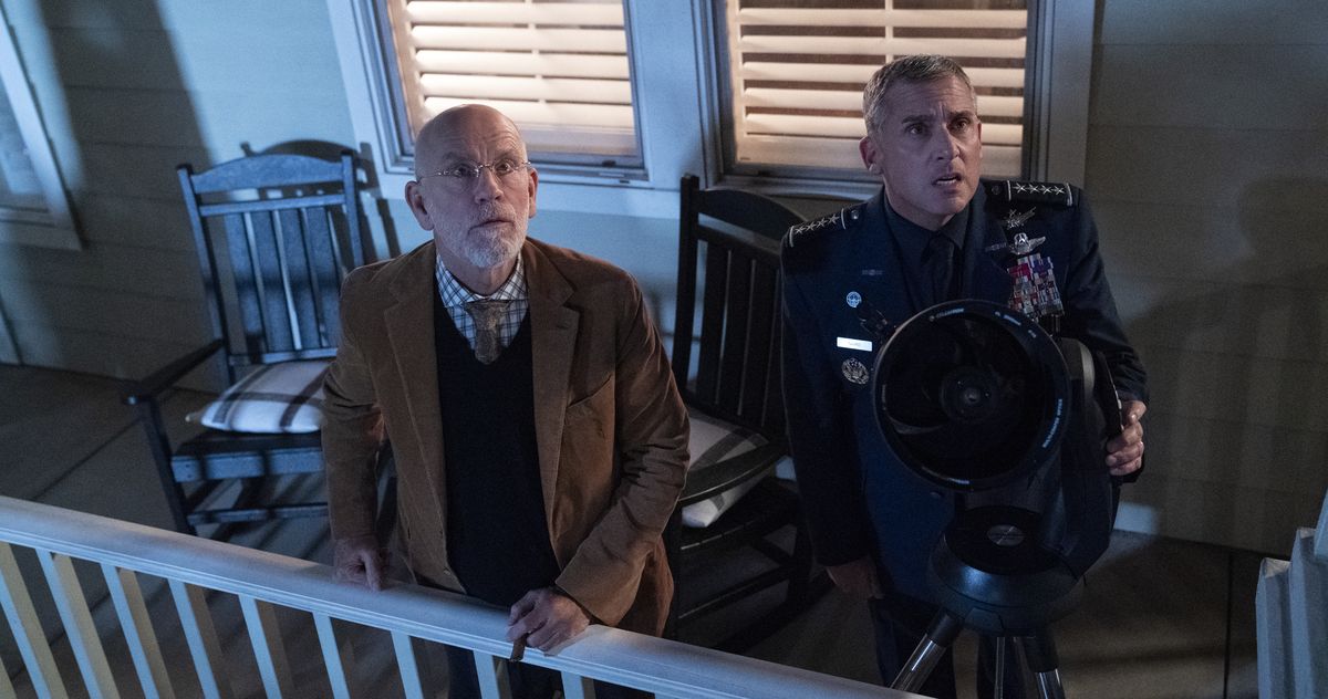 John Malkovich and Steve Carell stand on an exterior porch, staring upward in shock, in Space Force