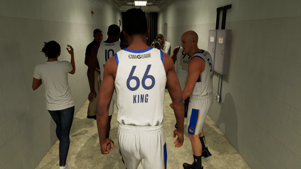 Cinque giocatori di basket in bianco lasciano gli spogliatoi per prendere la parola per la loro prima partita.