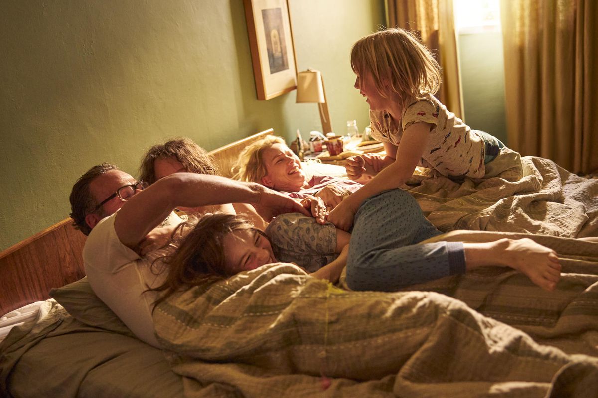 a family playing in bed