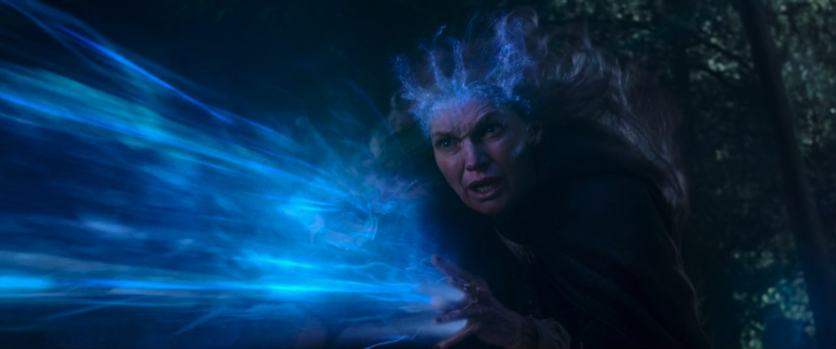 La madre di Agatha Harkness fa esplodere la magia blu dalle sue mani mentre le regala una corona magica blu in WandaVision.