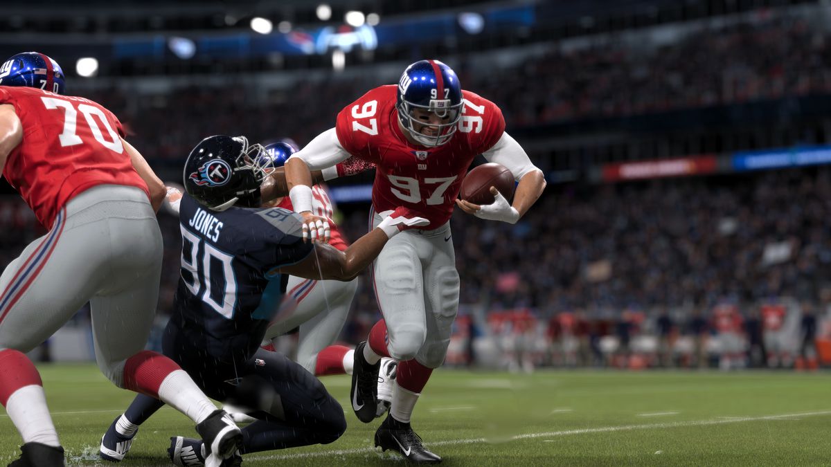 Un grande running back spinge a terra un difensore del Tennessee in una partita piovosa al Nissan Stadium di Nashville
