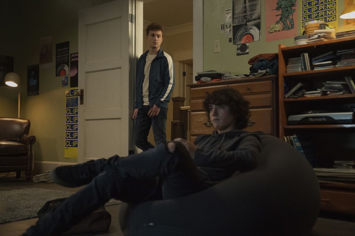 Il figlio atletico di Superman Jonathan (Jordan Elsass) guarda il figlio più timido Jordan (Alexander Garfin) giocare a un videogioco in una stanza buia in Superman & Lois