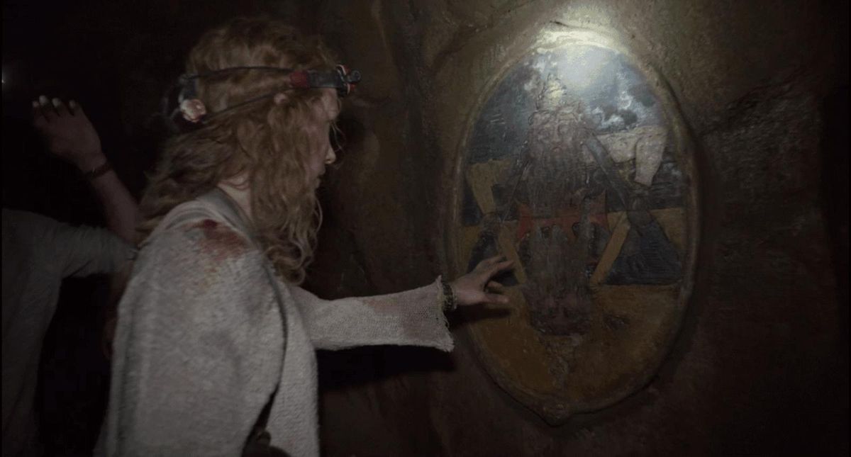 Perdita Weeks places her hand against an underground mural in As Above, So Below (2014)