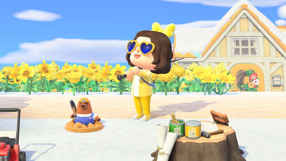 Animal Crossing character with brown hair wearing an all yellow outfit and holding a fishing pole, standing in front of a mole statue (Resetti)