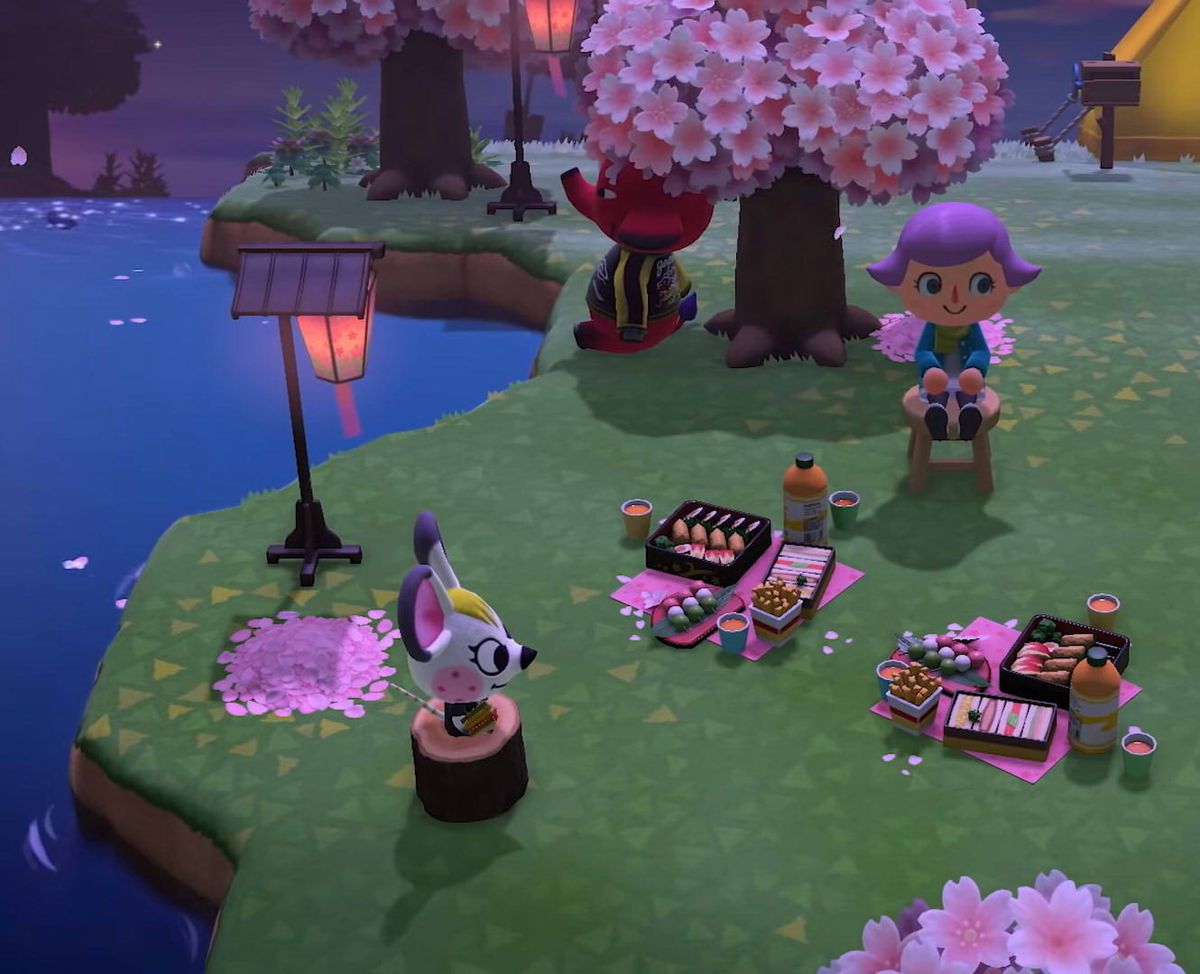 Animals sit around a villager at night under cherry blossom trees in Animal Crossing: New Horizons on Nintendo Switch