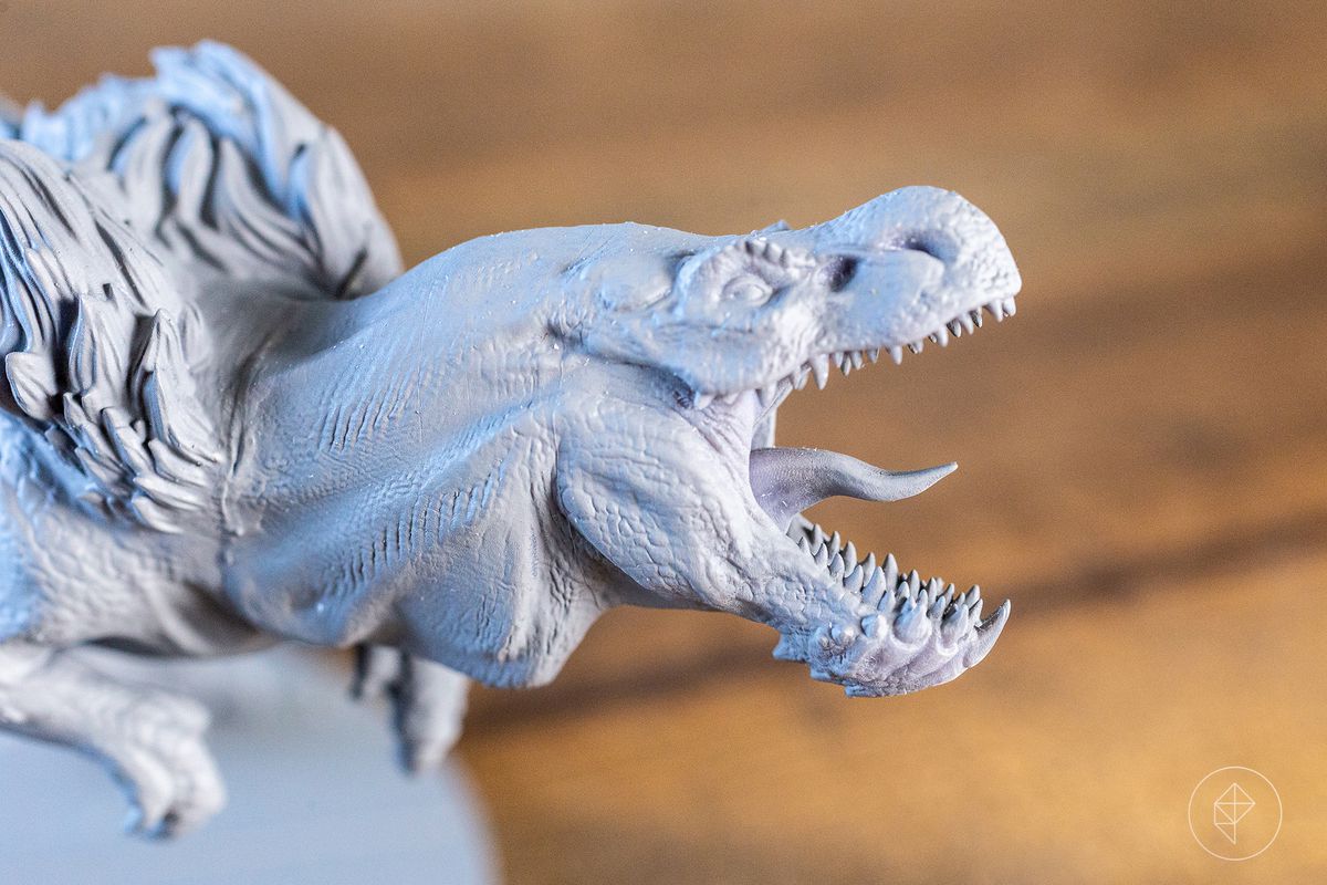 Una faccia simile a un rex ruggisce, la sua lingua è lunga e spinosa.