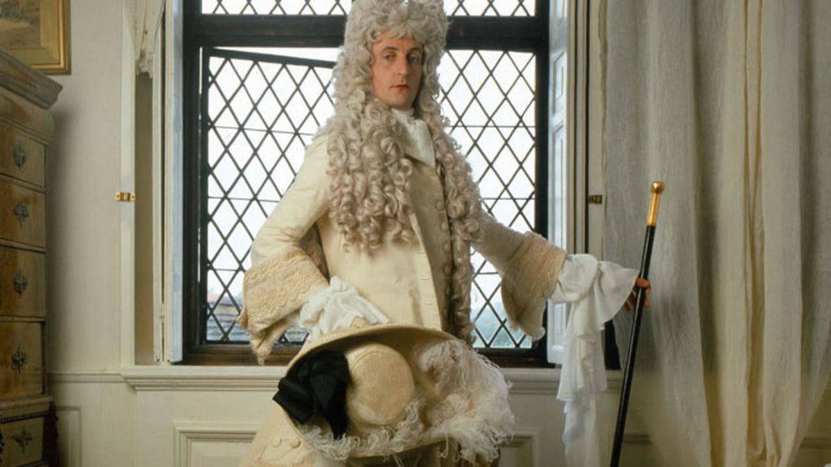 Il contratto del disegnatore: un uomo con una parrucca alza il bastone mentre posa