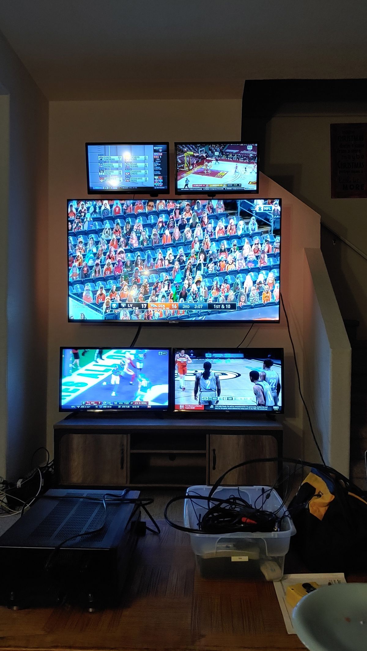 una foto di un televisore grande con quattro televisori più piccoli montati intorno - due sopra e due sotto - in un soggiorno