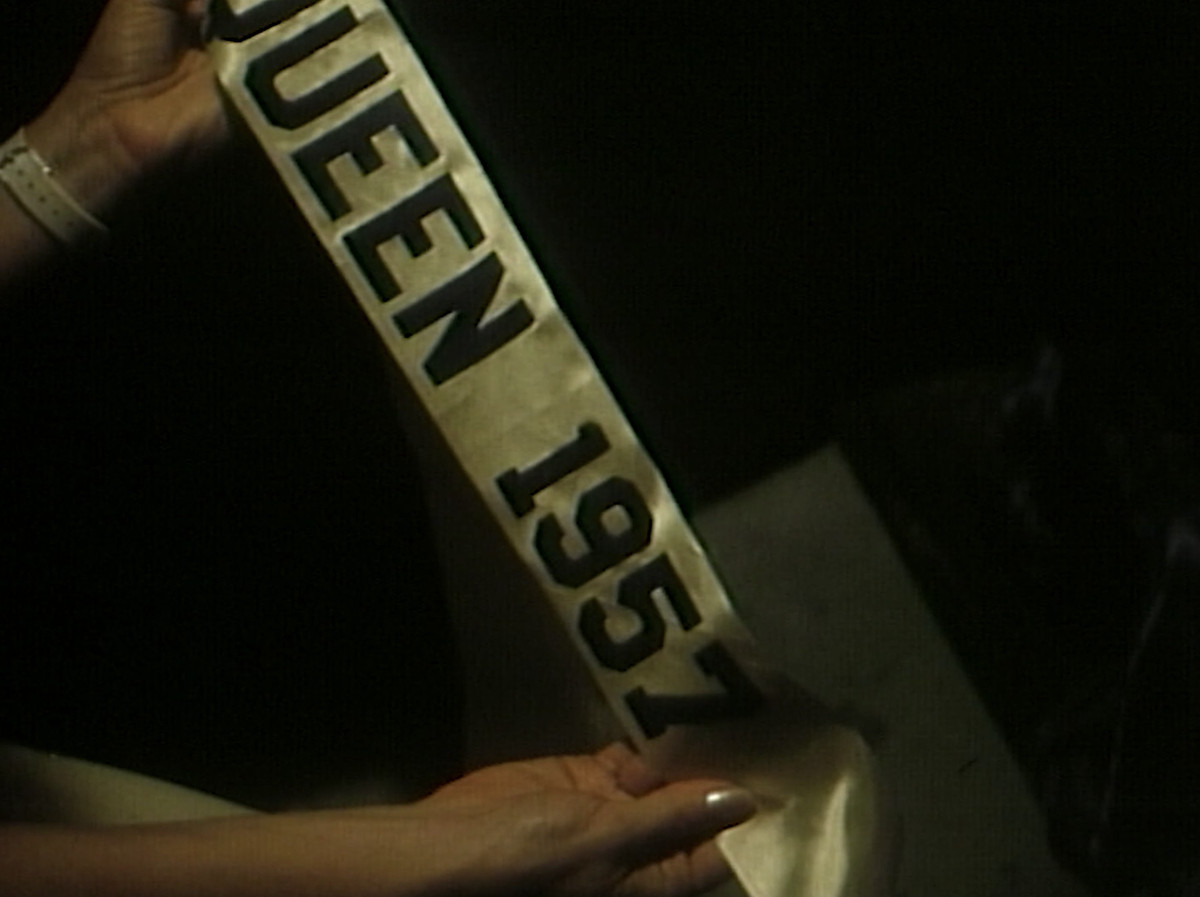 Le mani reggono una minacciosa fascia da reginetta del ballo del 1957 in Hello Mary Lou: Prom Night II