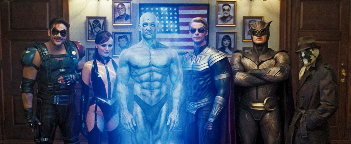 From left to right: The Comedian, Silk Spectre, Dr. Manhattan, Ozymandias, Nite Owl, and Rorschach pose for a photo in Zack Snyder’s Watchmen (2009)