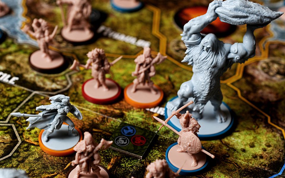 A giant hurls a boulder at a hero on the battlefield in Blood Rage.