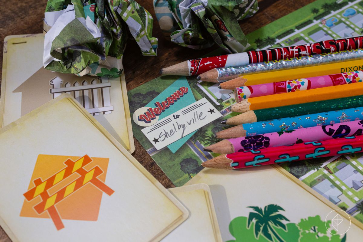 A stack of pencils next to a couple cards from Welcome To... A pile of crumbled up tear sheets sit along the top of the frame.
