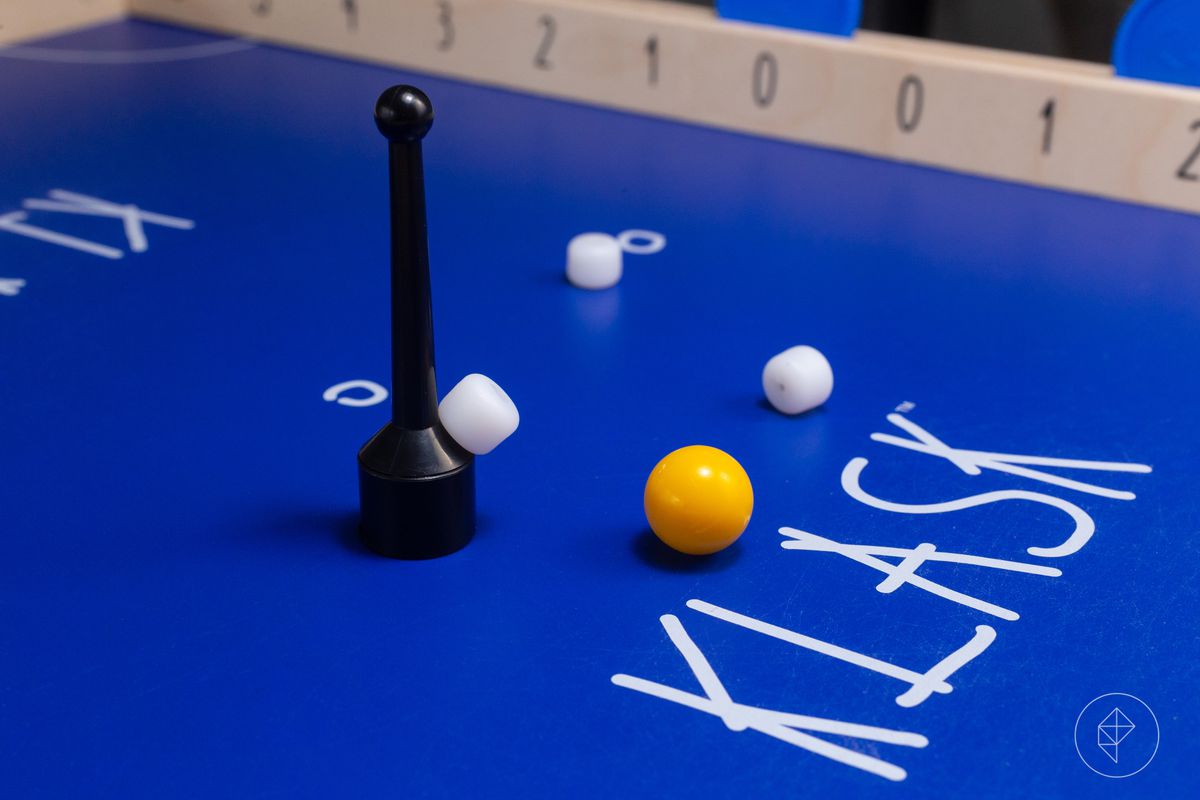 A close-up of the playing surface in Klask, showing the wear on the table from the striker sliding across the surface.