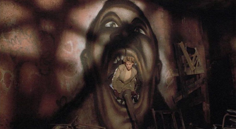 Helen Lyle (Virginia Madsen) striscia attraverso la bocca di un murale di Candyman nel film Candyman del 1992 diretto da Bernard Rose