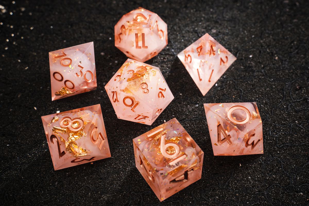 Una macchia d'oro emerge dall'interno dei dadi color pesca.