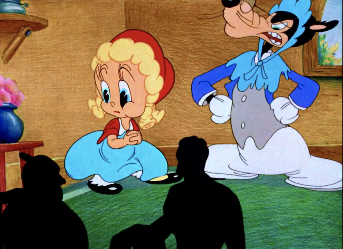 Il lupo cattivo, dopo aver messo alle strette Cappuccetto Rosso, interrompe la lotta per lamentarsi delle sagome delle persone che prendono posto a teatro