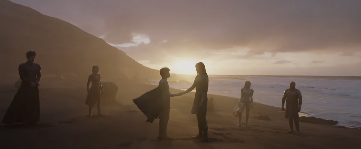 Il cast di Eternals bazzica su una spiaggia nei loro costumi.