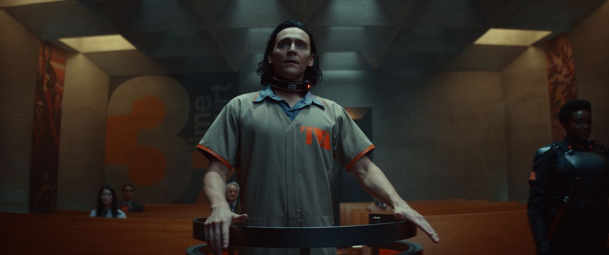 Loki in una tuta poco lusinghiera da prigioniero della TVA si trova sul banco degli imputati a Time Court