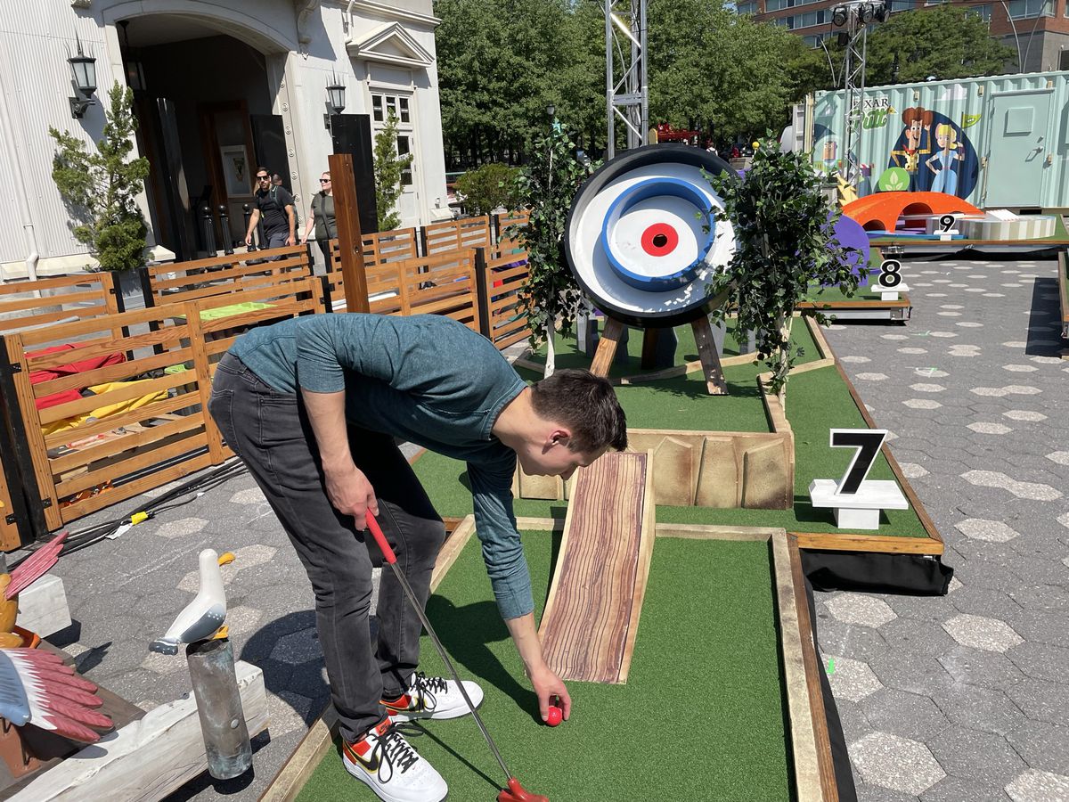 Austen si accovaccia accanto a un buco che ha la forma di un bersaglio di tiro con l'arco