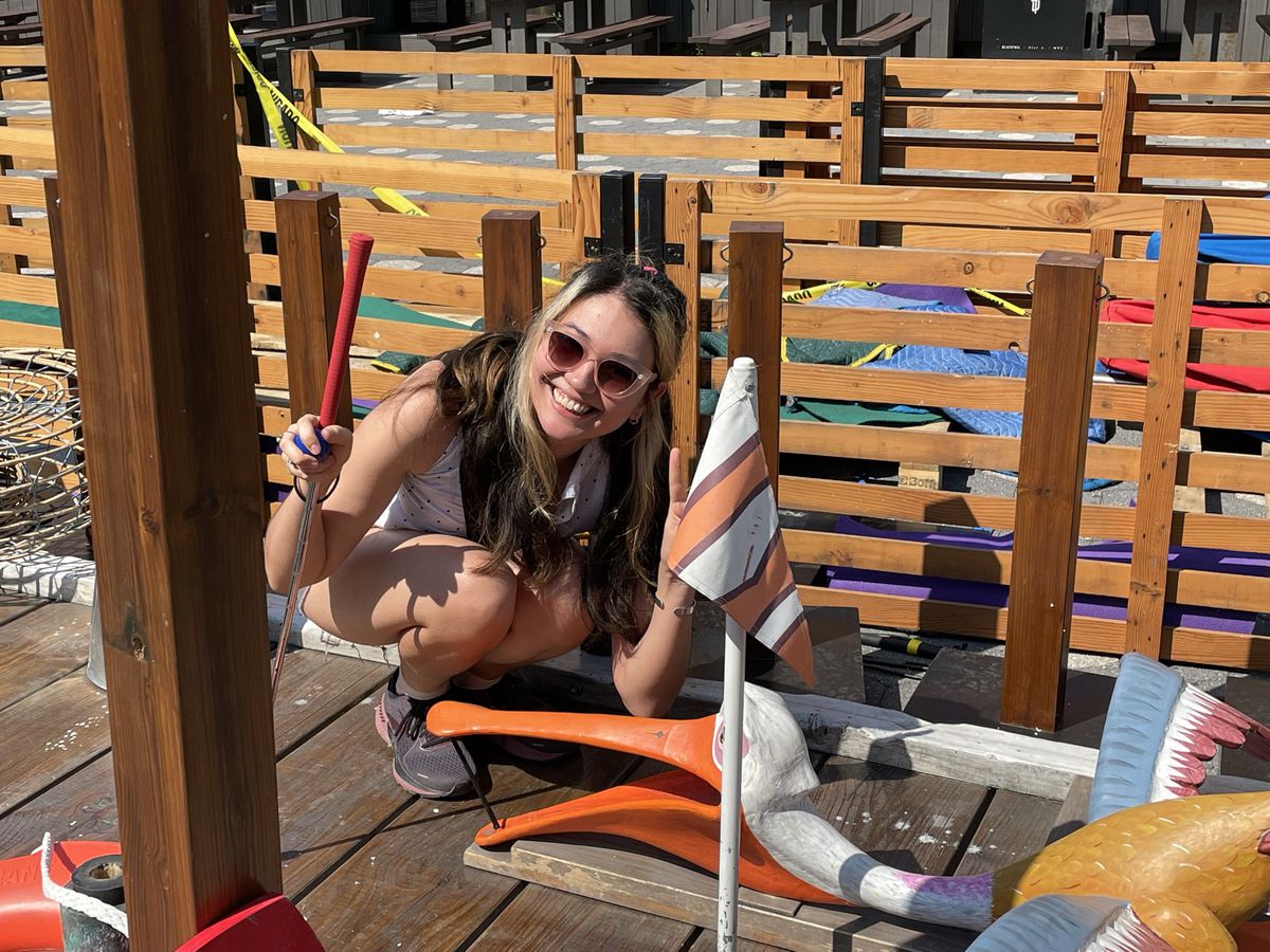 petrana si accovaccia accanto a un pellicano dalla bocca larga