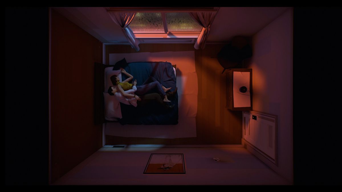 una ripresa dall'alto di un uomo e una donna che si accarezzano un letto in una camera da letto in Dodici minuti