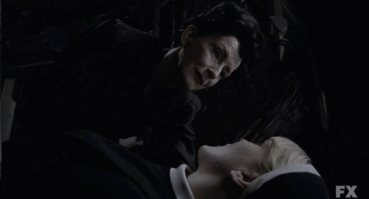 a black clad figure looks at a young woman before she takes her for death