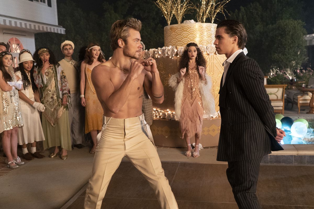 un adolescente a torso nudo che sta per combattere un ragazzo in giacca e cravatta