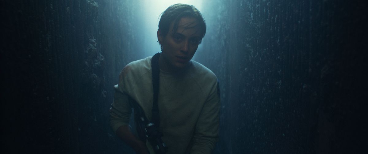 Nora Arnezeder, con i capelli bagnati e dall'aria allarmata, si muove in uno spazio scarsamente illuminato in The Colony