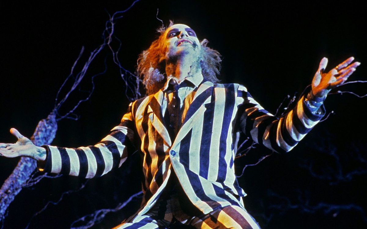 Michael Keaton as Beetlejuice with his arms outstretched