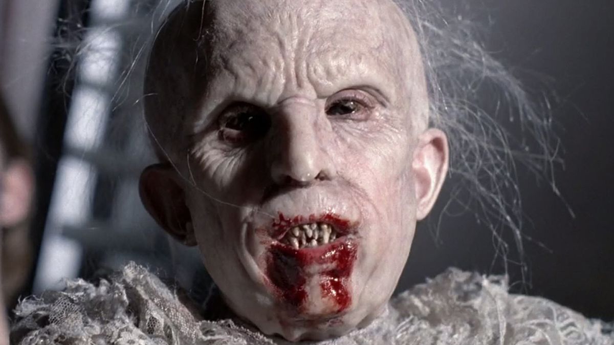 a pale child with a wrinkled face and sharp blood-splattered teeth