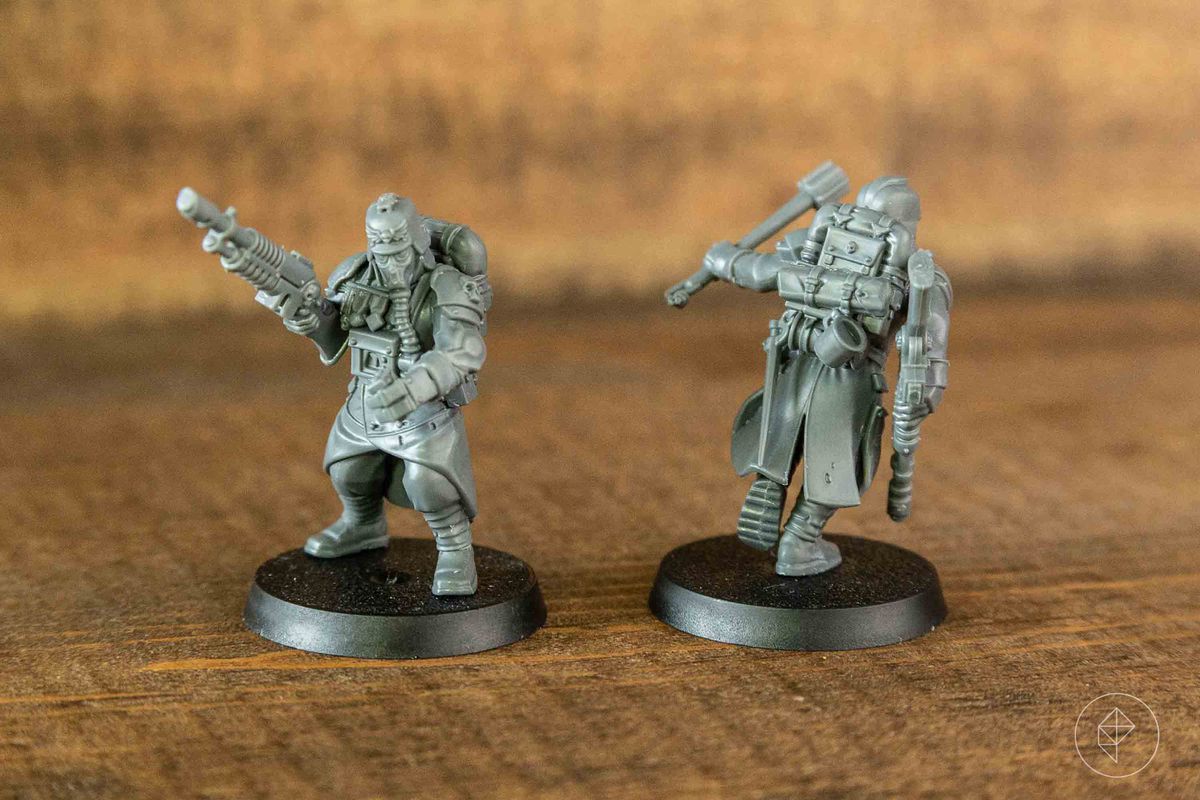 Due figure di plastica grigia su uno sfondo di legno.