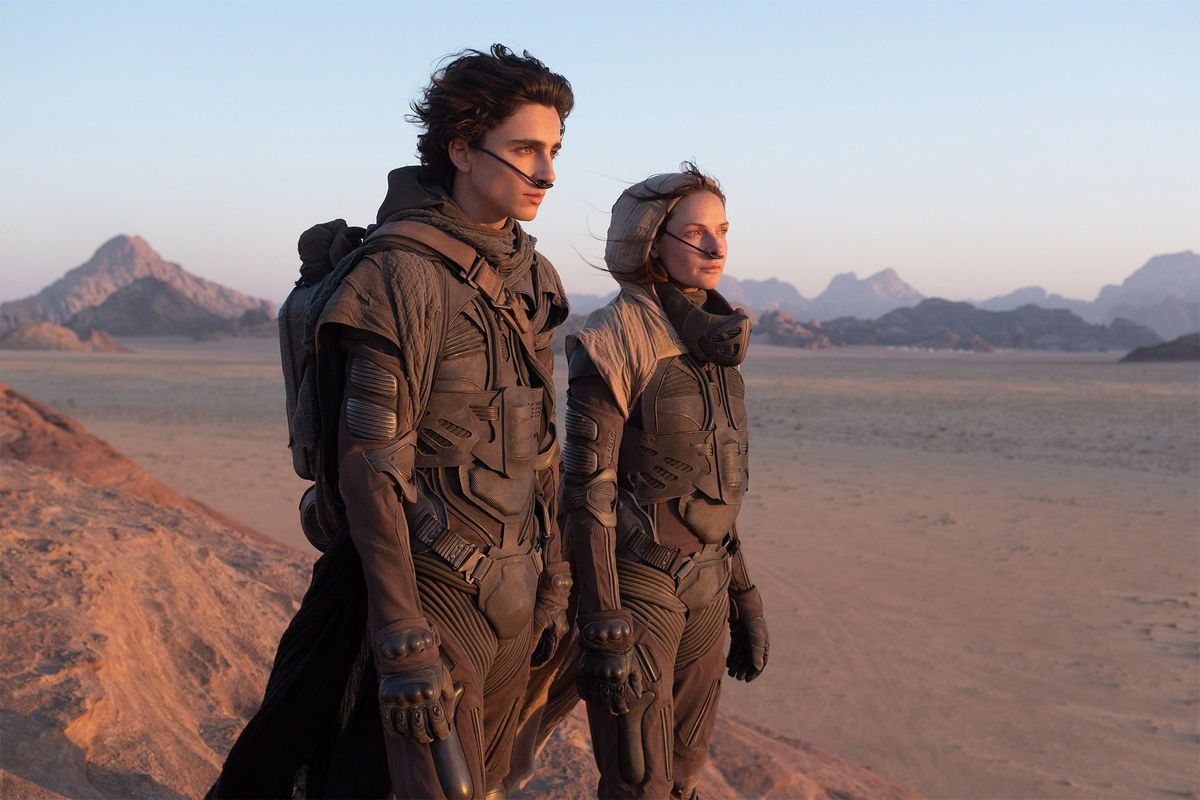 Timothée Chalamet nei panni di Paul Atreides e Rebecca Furguson nei panni di Lady Jessica Atreides si trovano nel deserto sul set di Dune di Denis Villenueve.