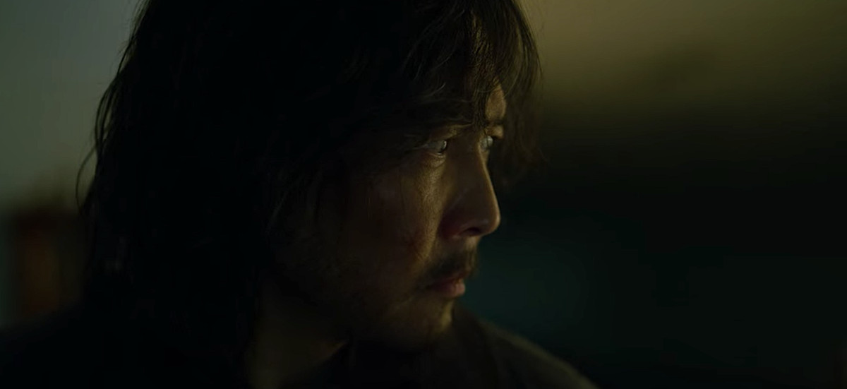 Gi-hun, ora con i capelli lunghi, la barba e stanco, alla fine di Squid Game