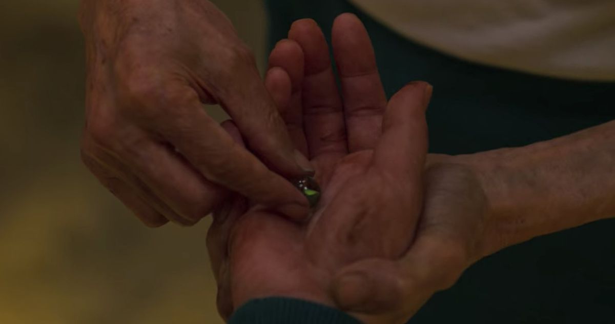 Oh Il-nam mette la sua ultima biglia nella mano di Seoung Gi-hun in Squid Game.