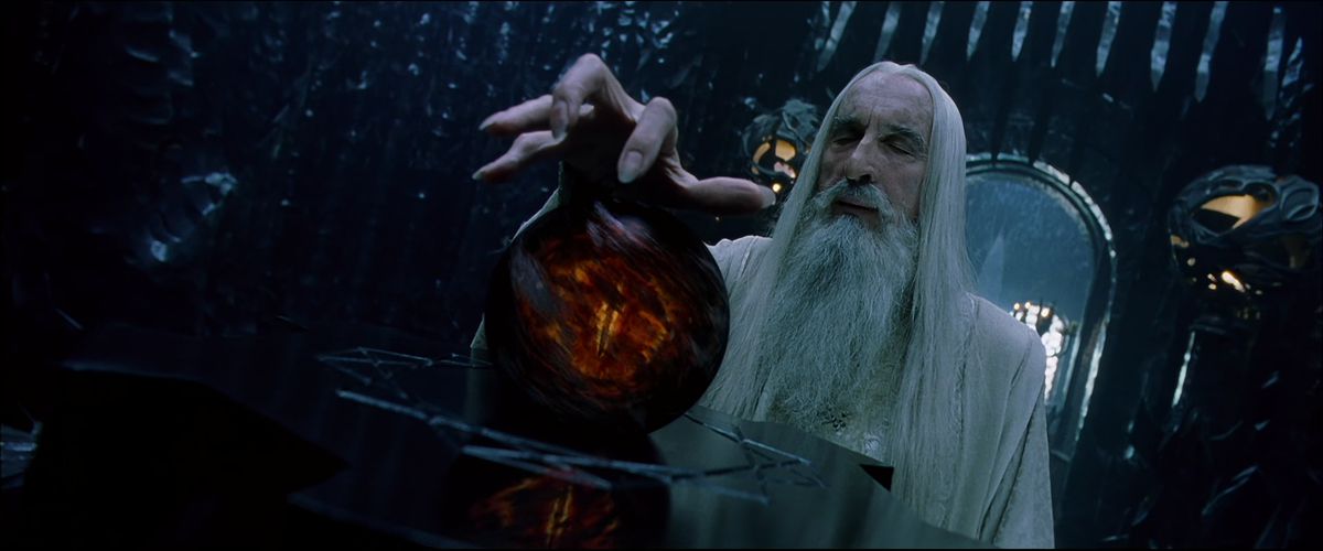 Saruman fa un gesto con la mano come un artiglio sul Palantir - che mostra l'occhio di Sauron avvolto in un fumo scuro - ne Il Signore degli Anelli: La Compagnia dell'Anello.
