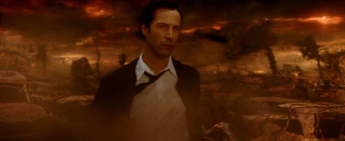 Constantine walks through an ashen, orange apocalyptic wasteland that might be hell
