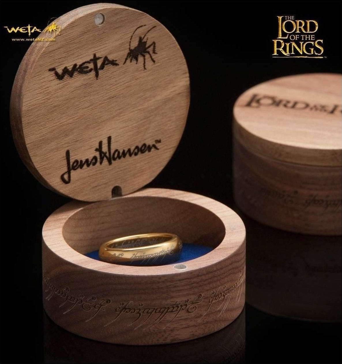 A replica of the One Ring displayed in a gift box bearing the logos of Wētā Workshop and Jens Hansen.