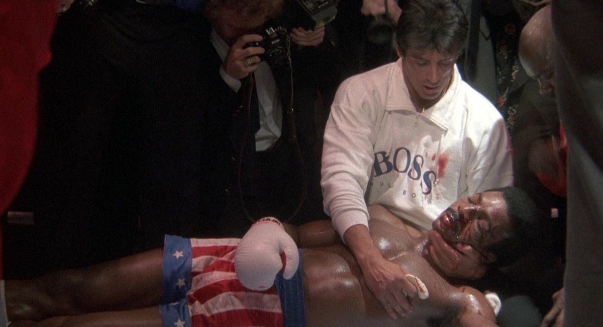 Rocky tiene tra le braccia un Apollo Creed morente dopo un incontro di boxe