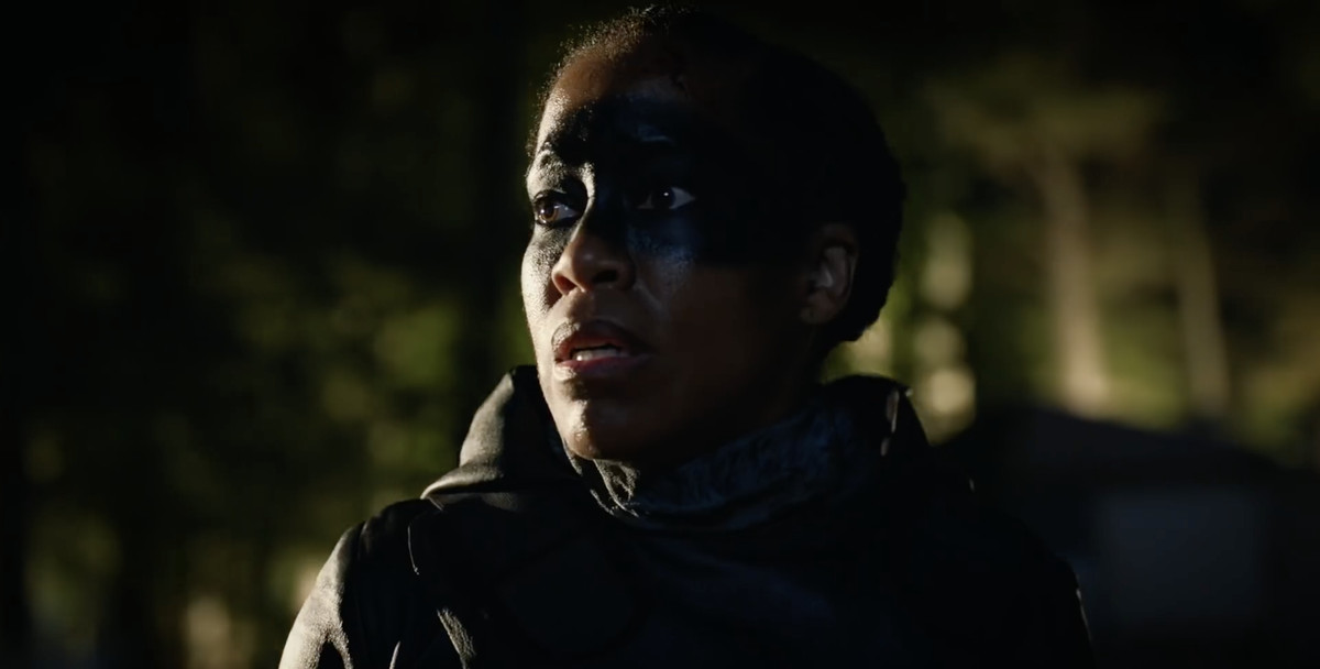 Angela Abraham (Regina King), con la vernice scura sugli occhi, osserva lo svolgersi del caos.