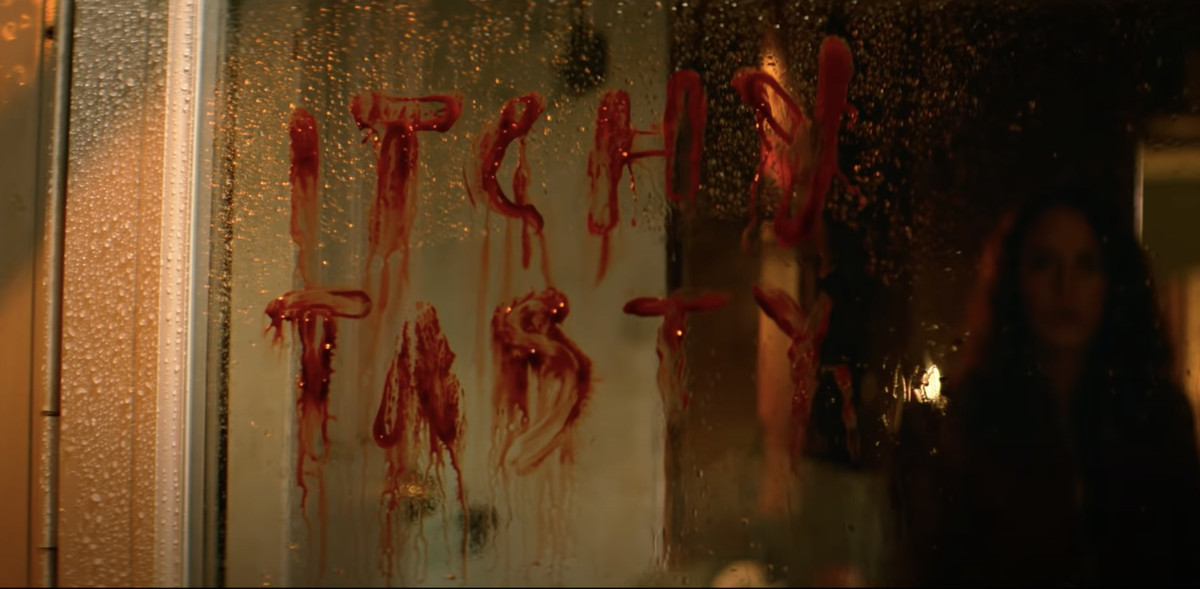 Un vicino squilibrato scarabocchia un'iconica frase di un videogioco su una finestra in Resident Evil: Welcome to Raccoon City.