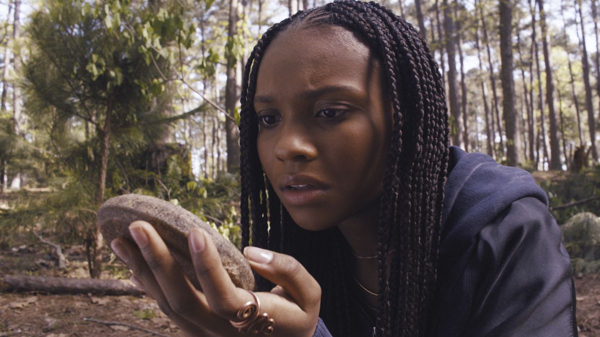 Naomi picks up a rock